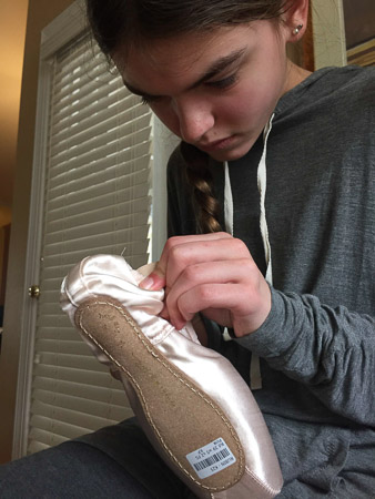 Learning to sew her own pointe shoes