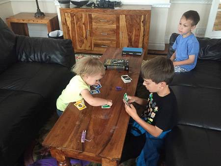 Jonah teaching Marin the play Uno. Adrian is not impressed.